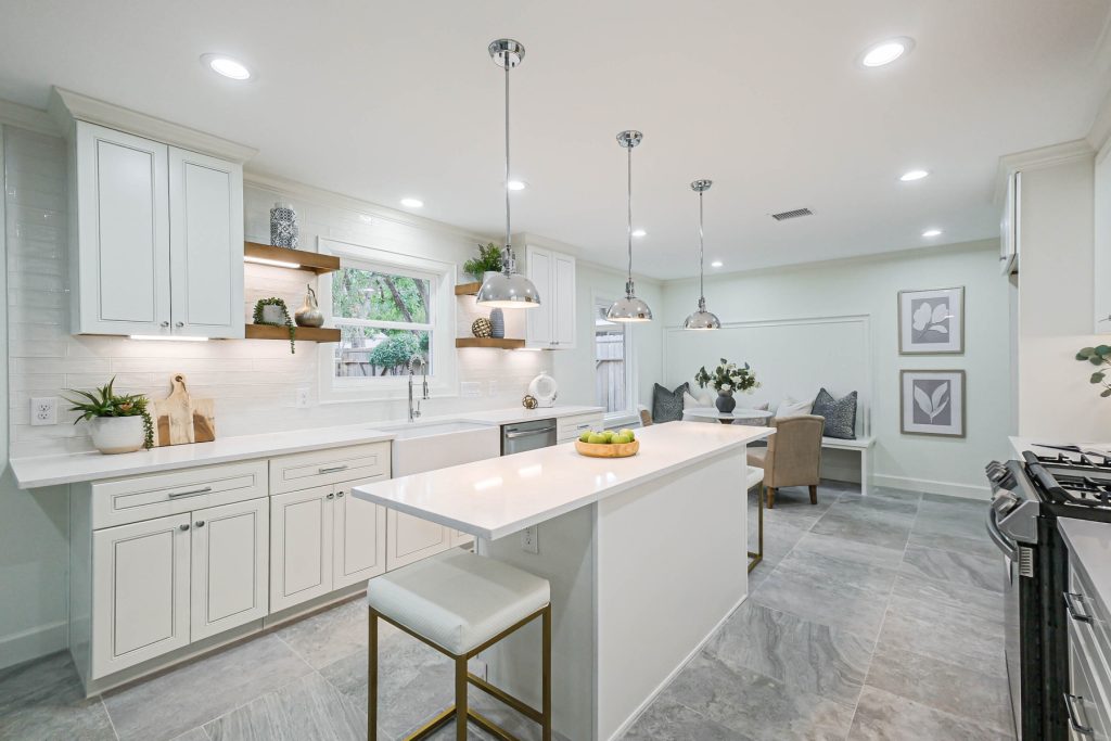 Kitchen with white cabinets, island and pendant lights in a Westbury renovation, Houston
