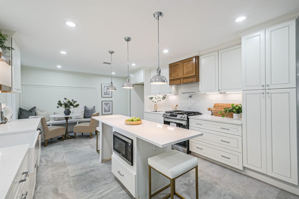 Renovated kitchen with island seating and gas range in a Westbury home