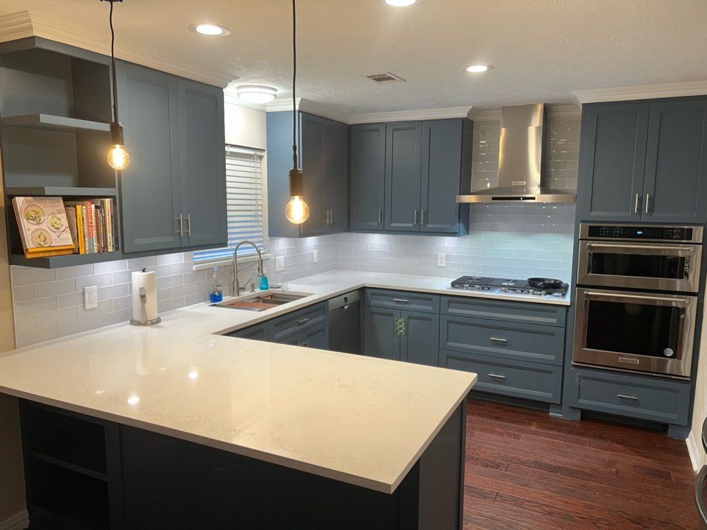 Open kitchen with pendant lights and quartz peninsula in an Oak Forest renovation