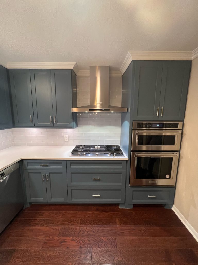 Kitchen with blue-gray cabinets, stainless range hood and wall ovens in an Oak Forest renovation