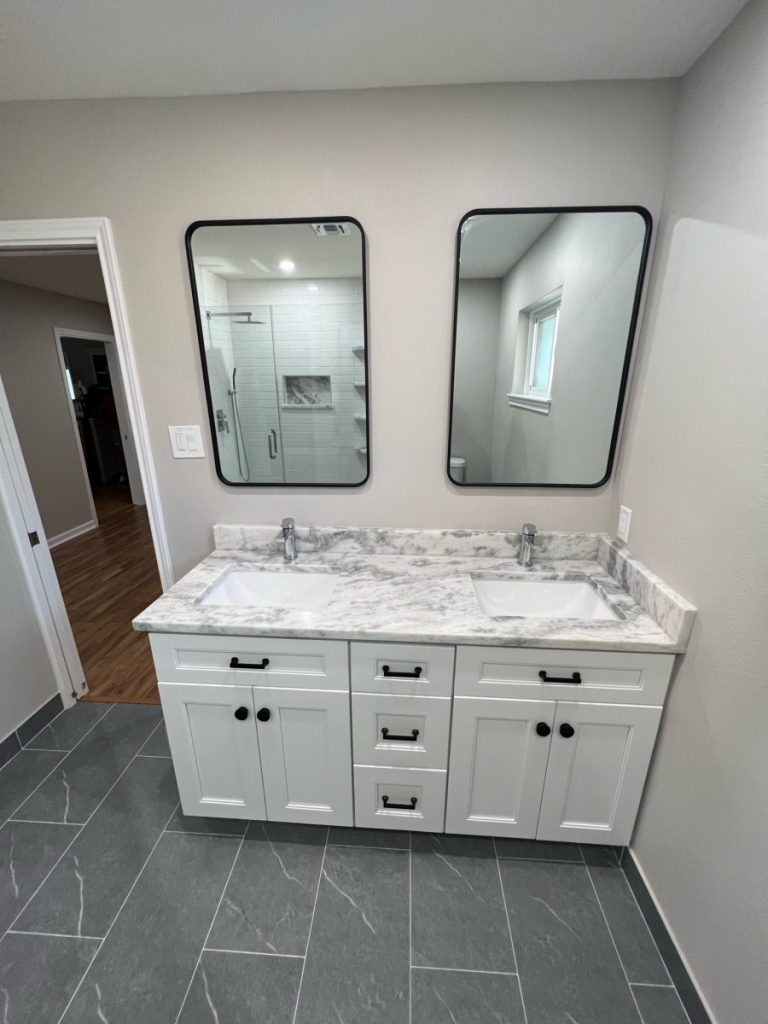 Double vanity with marble countertop and black mirrors in a Spring Branch remodel