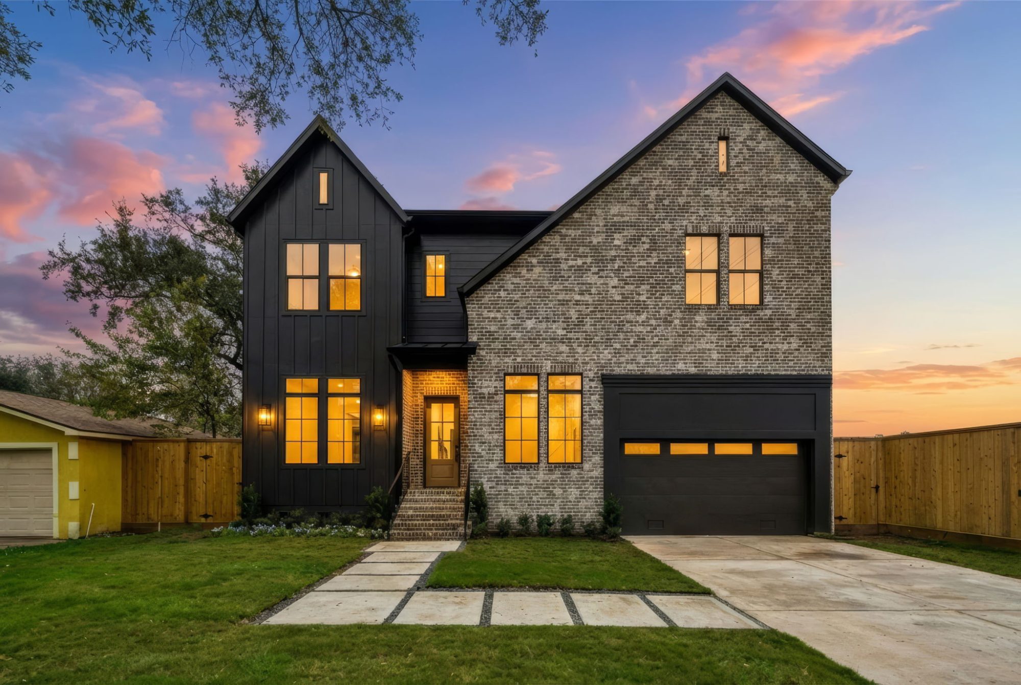 Front of a new two-story Bellaire custom home with stone and black board-and-batten siding