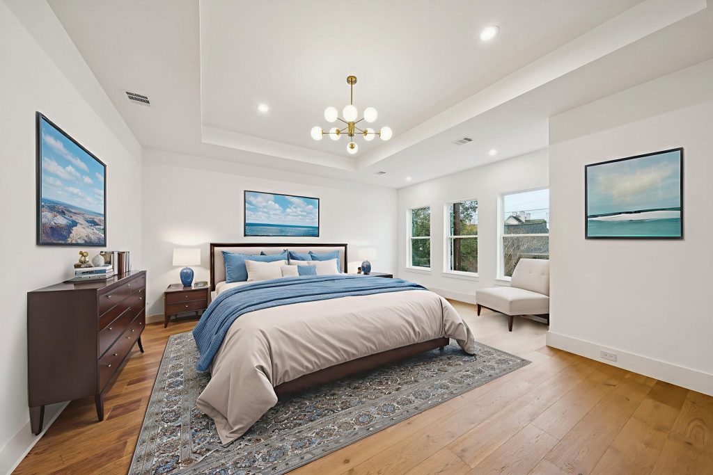 Staged primary bedroom with tray ceiling in a Bellaire custom home