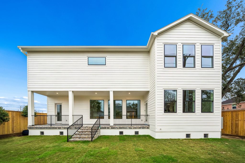 Rear exterior with covered porch and white siding on a Bellaire new construction home