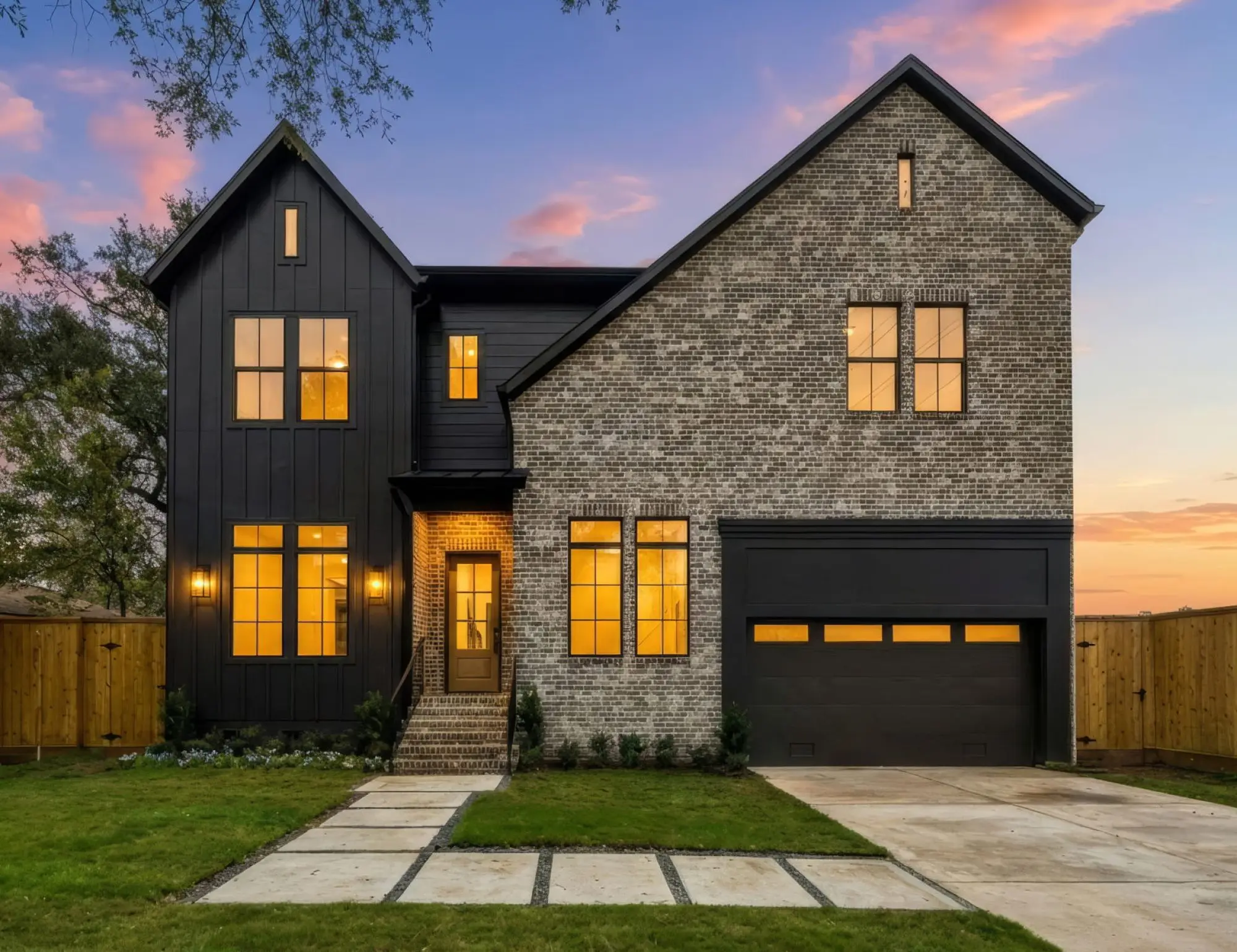 Modern farmhouse custom home in Bellaire, TX with black siding and stone at dusk