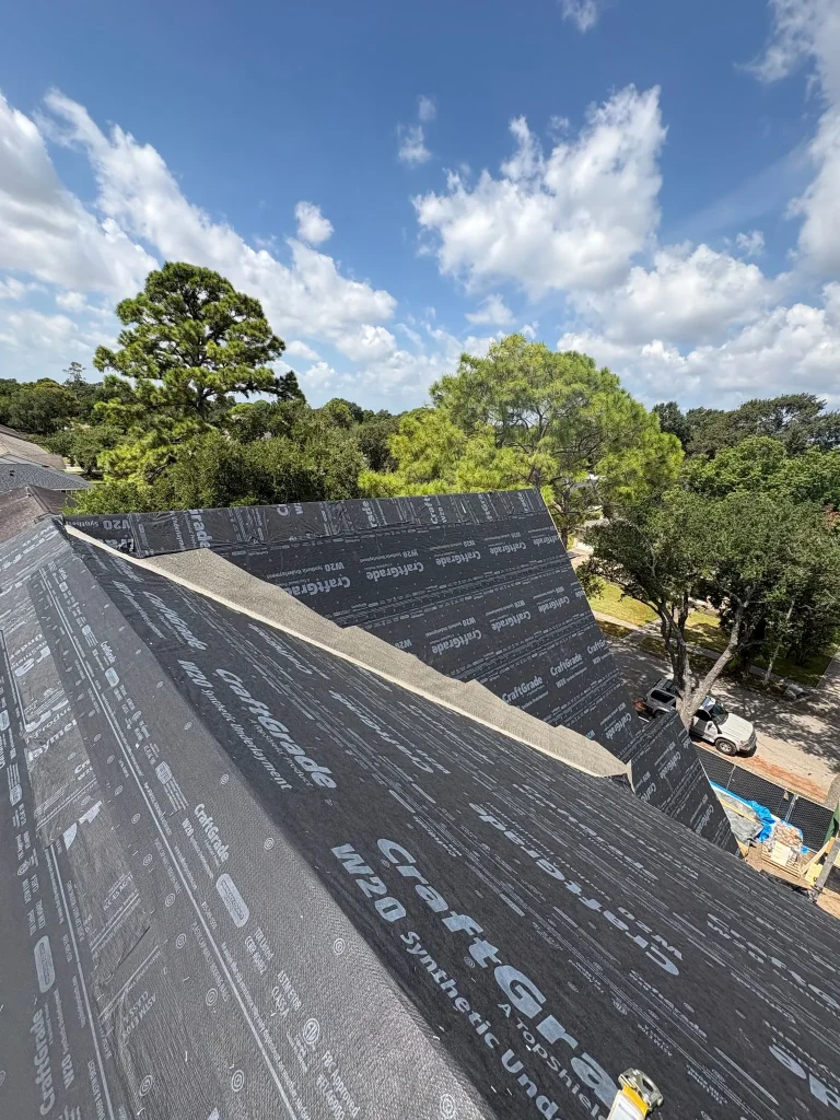 Roof underlayment on a steep roof during construction, ready for wind-driven rain